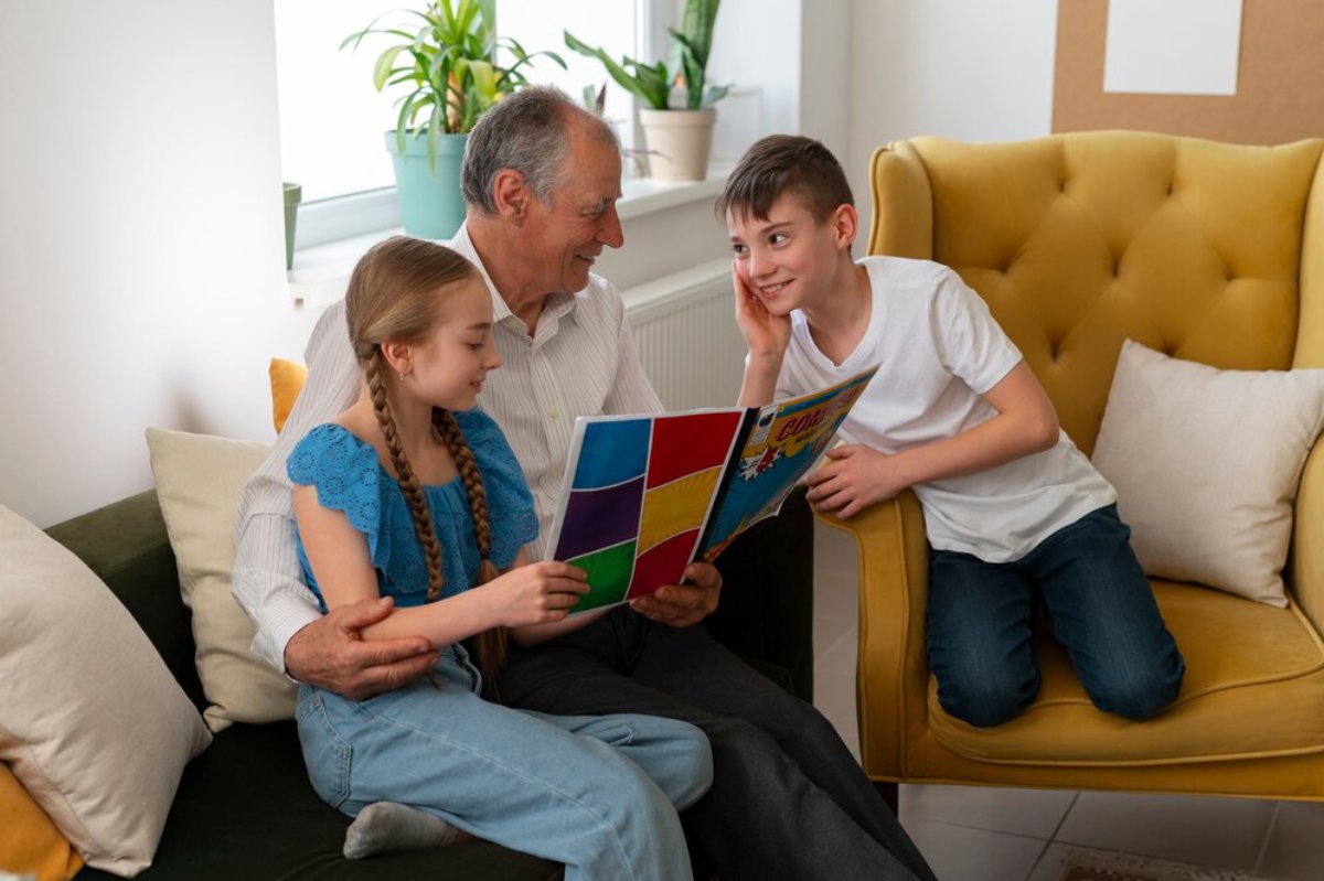 Grandfather reading a colorful comic book to his granddaughter and grandson in a cozy living room.
